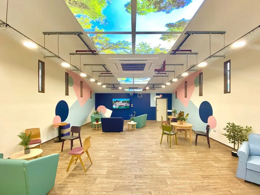 CW+ studio with sofas, mural painted walls and an illuminated ceiling