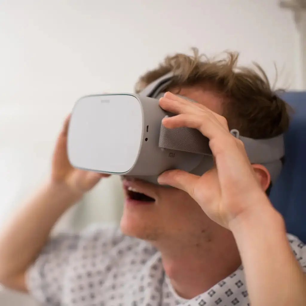 Man in hospital gown with VR mask looks awestruck