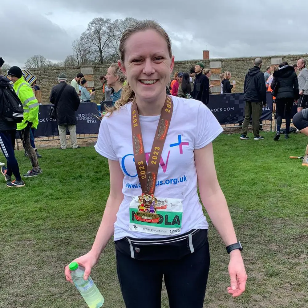 Nicola Rose, staff member, wearing a medal after completing a half marathon
