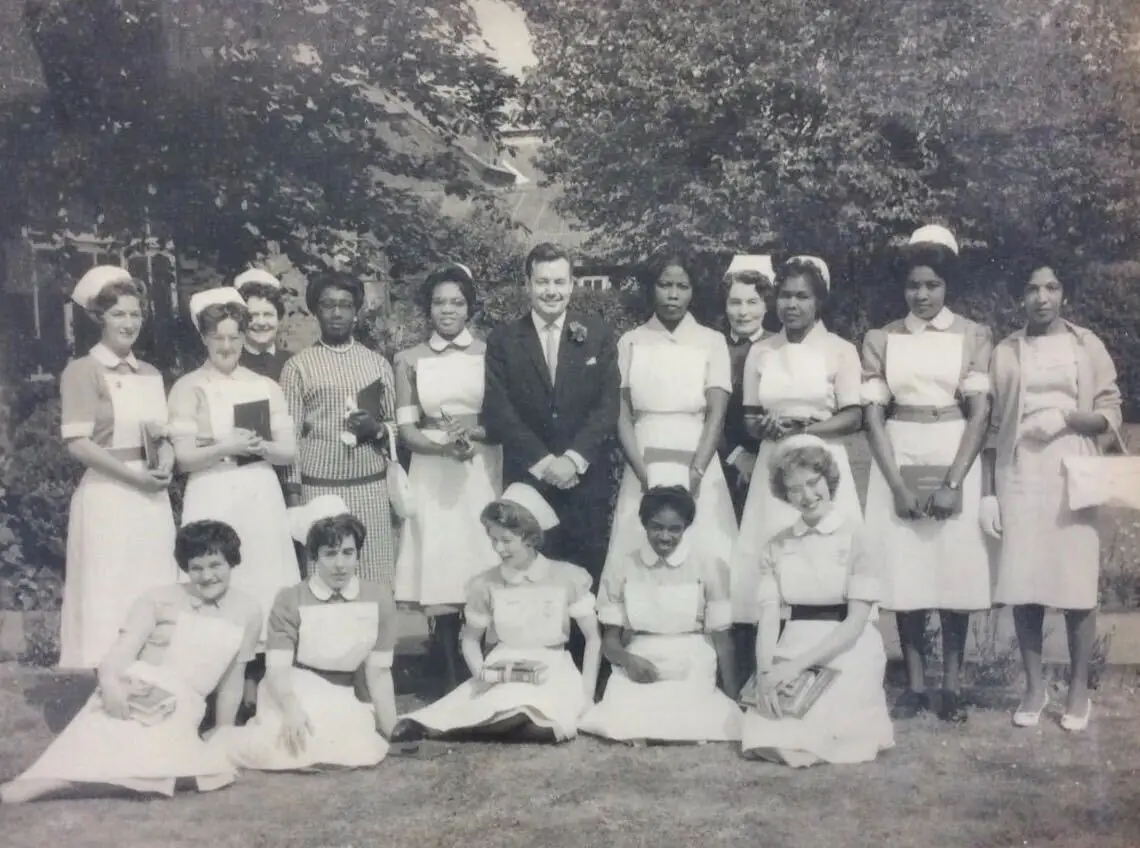 Women in medicine: an old photo of nurses in a garden. The back row is standing and the front row is sitting on the grass