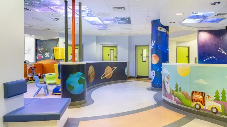 Saturn Ward, a children's outpatients department with a cosmic theme - there are planets and rockets on the walls and swirling galaxies on the ceiling, with colourful doors and furniture
