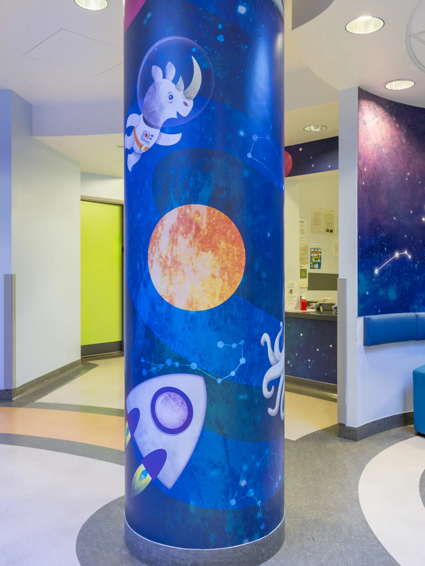 Pillar painted blue with a planet, rocket and other space-themed designs