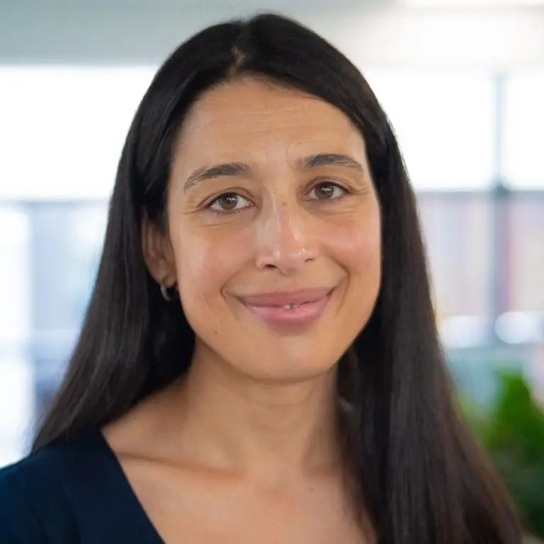 Woman with long straight dark hair smiling at the camera