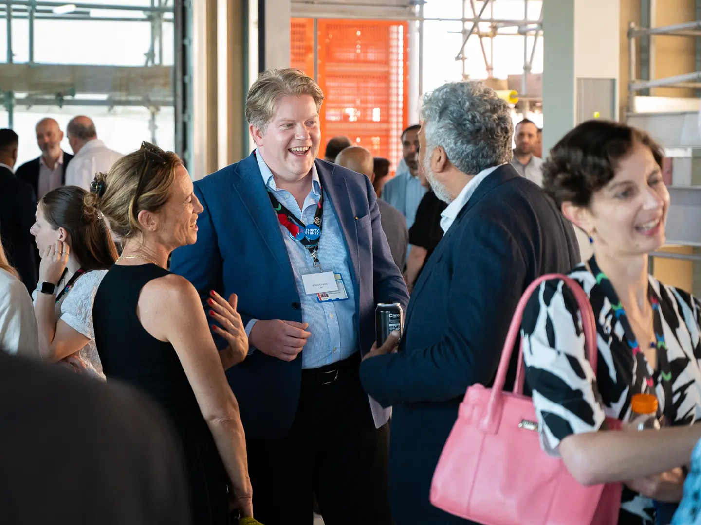 People (including CW+ Chief Executive Chris Chaney) chatting and laughing at an event