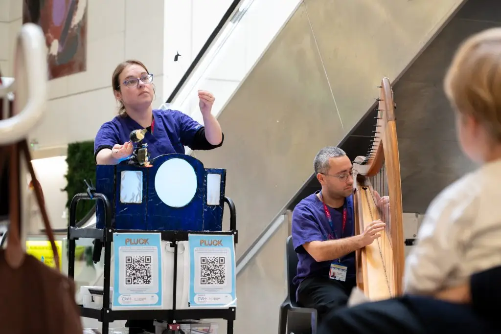 A puppeteer and harpist perform to a child at Chelsea and Westminster Hospital as part of the CW+ Arts for All programme, which aims to improve patient experience by providing access to music, performance and creative activities.